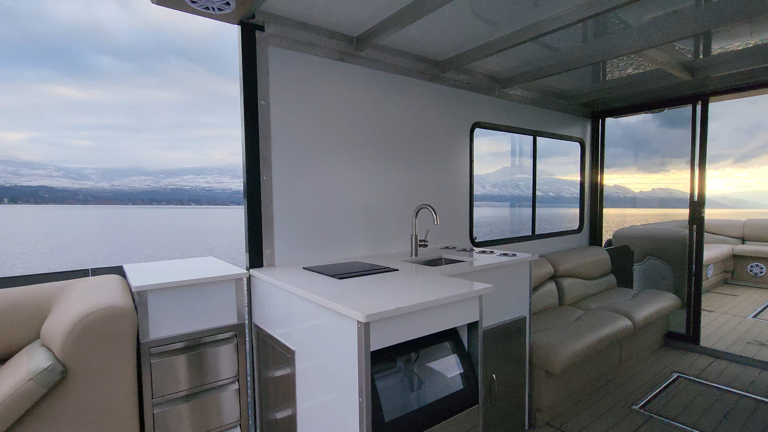 Galley counter, sink, refrigerator and upholstered cabin seating.