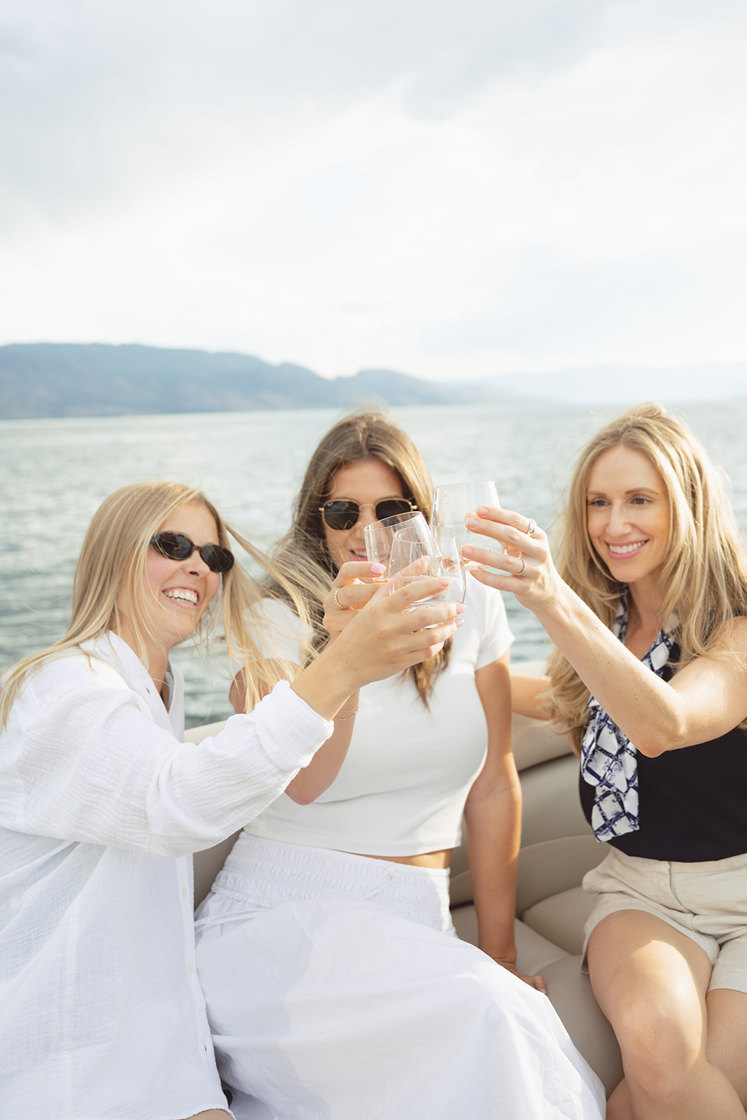 Three guests clink glasses in the bow lounge.